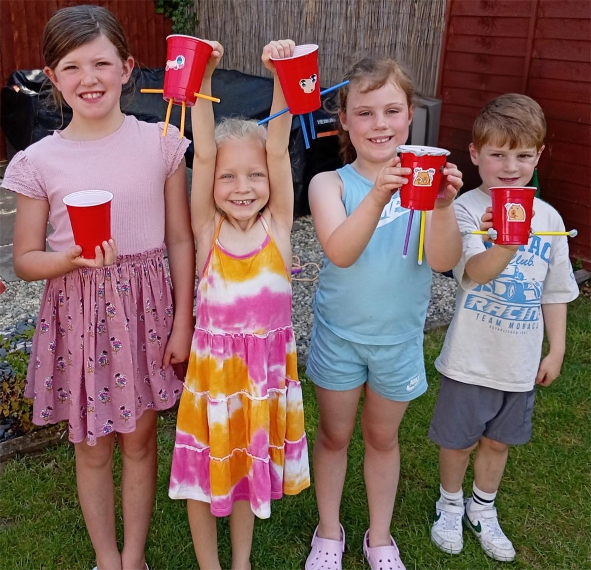 Four children proudly showing the cup creatures they made at The Curiosity Classroom