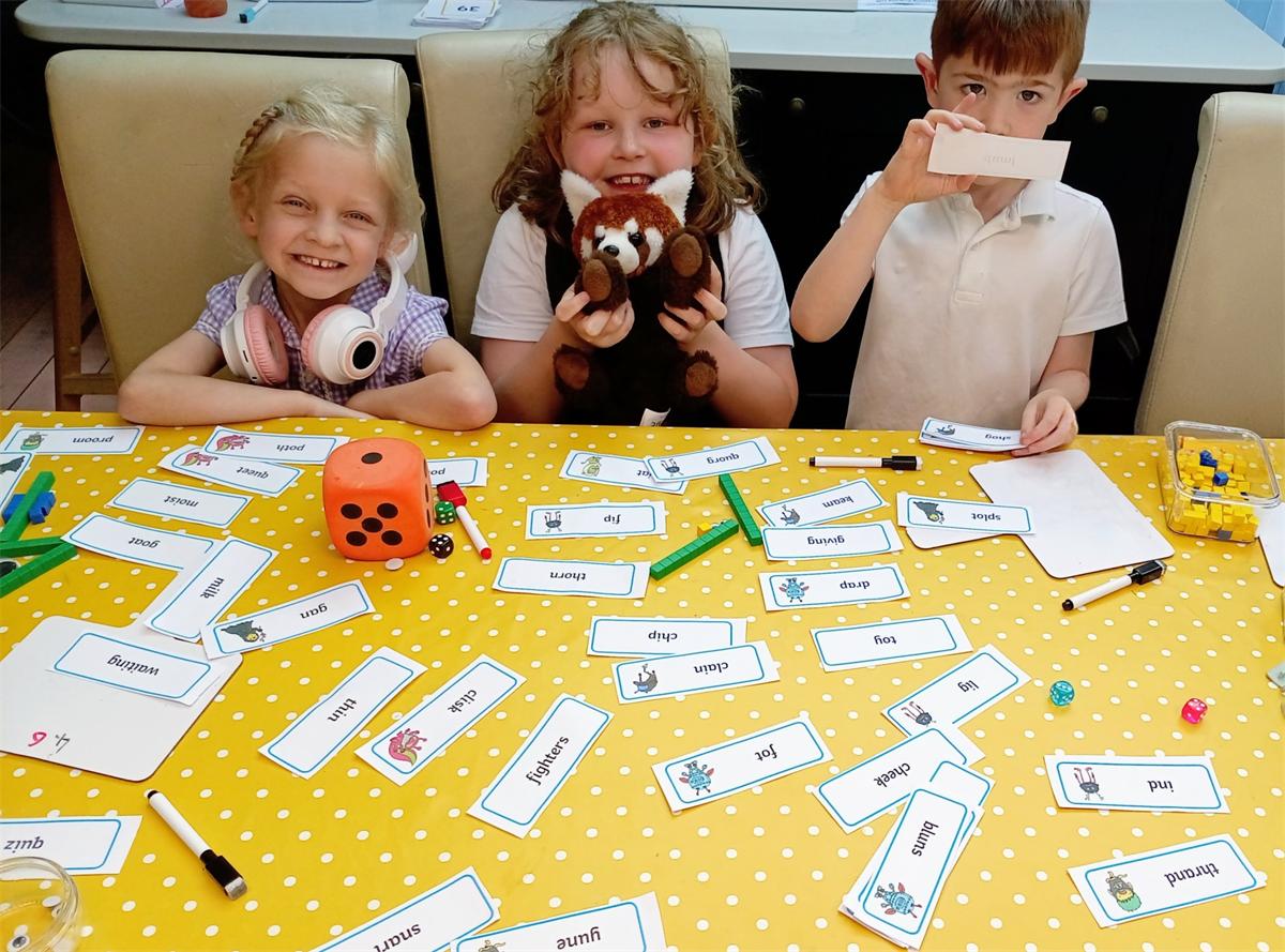Children playing a phonics game at the learning table