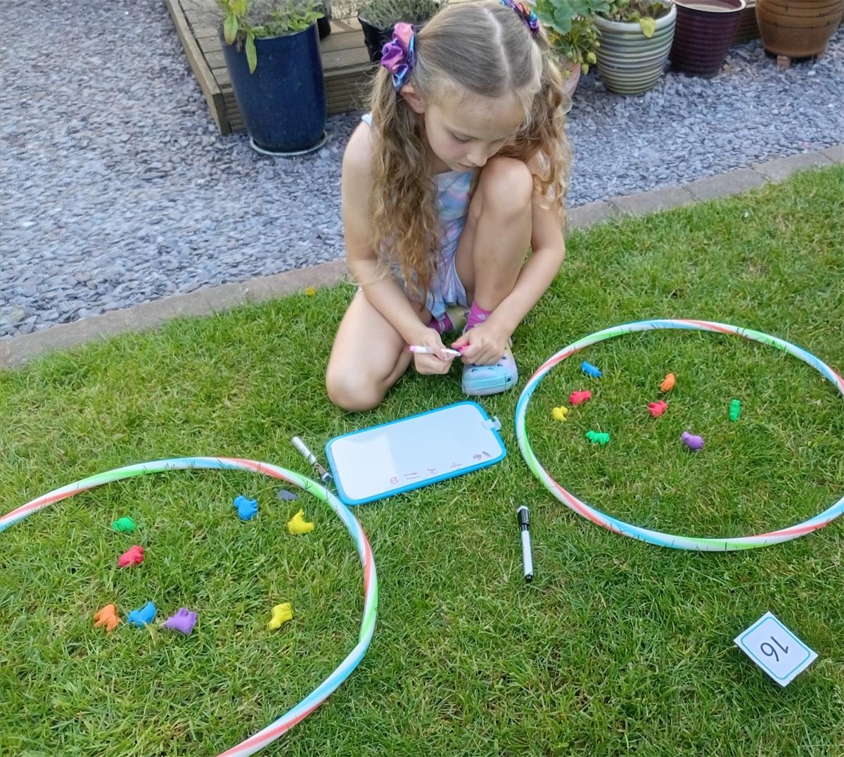 A pupil with a nature-based counting activity in the garden